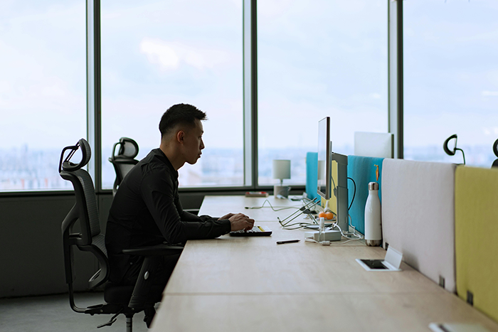 Employee focused at computer in modern office environment amid boss bullying claims and workplace conflict.