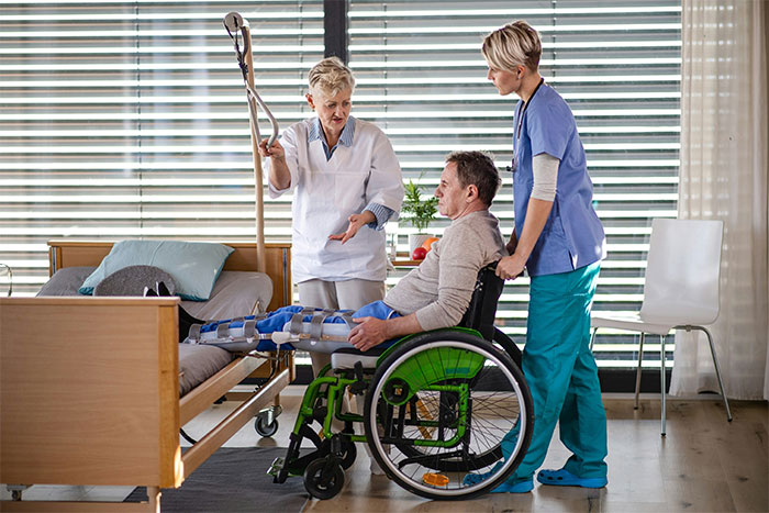 Woman in wheelchair receiving medical care for physical consequences after an accident caused by her fiancé.